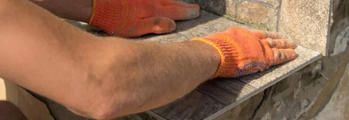 Person verlegt Fliesen auf Treppe